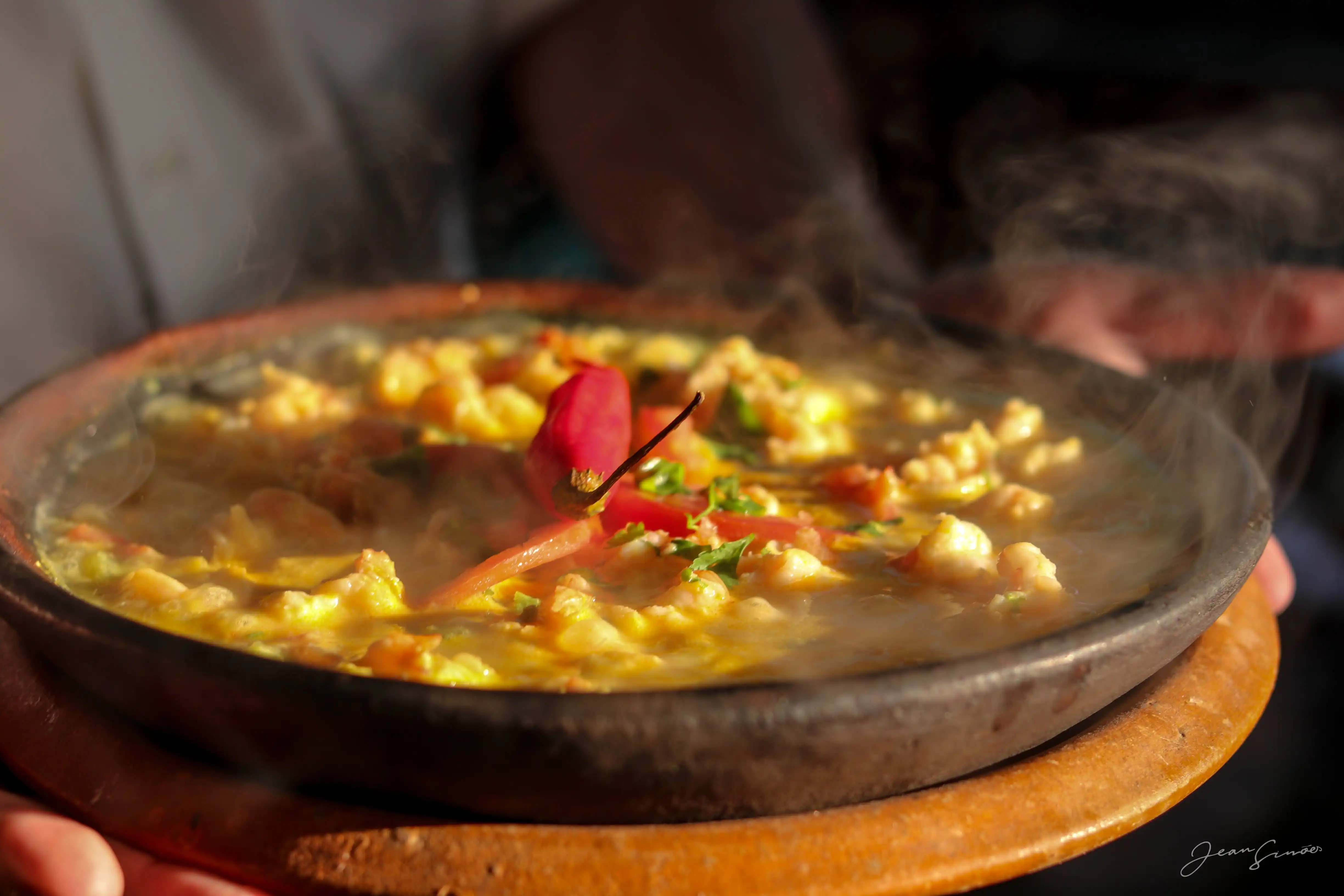 Moqueca baiana tradicional servida na panela de barro com peixe e camarões